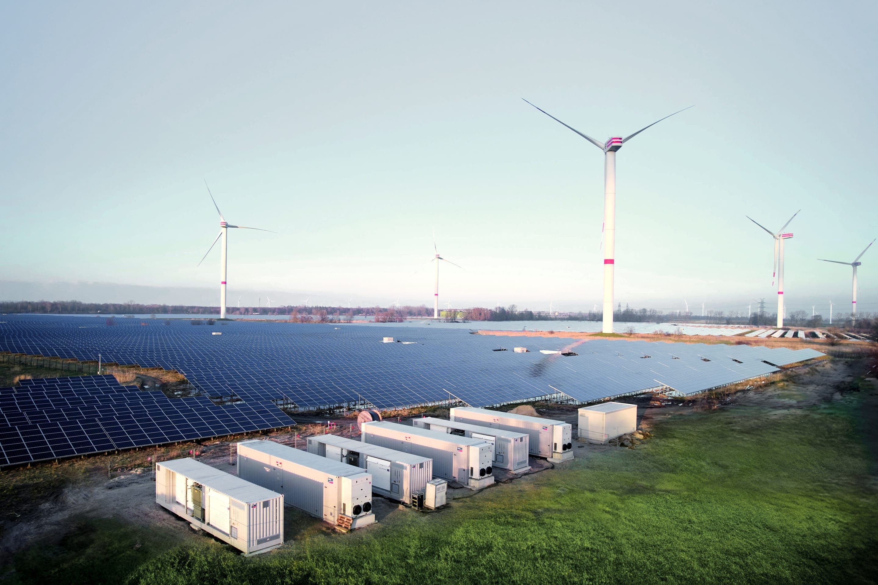 Batteriespeicher Büttel: Speichercontainer neben einer Photovoltaik-Freiflächenanlage und Windenergieanlagen in Schleswig-Holstein